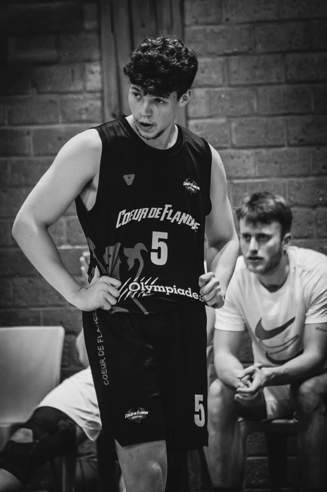 Portrait de Samuel en maillot n°5 de Coeur de Flandre, mains sur les hanches pendant un arrêt de jeu.