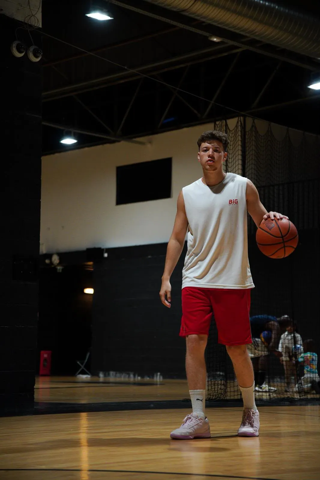 Samuel en dribble sur un parquet de salle de basket.